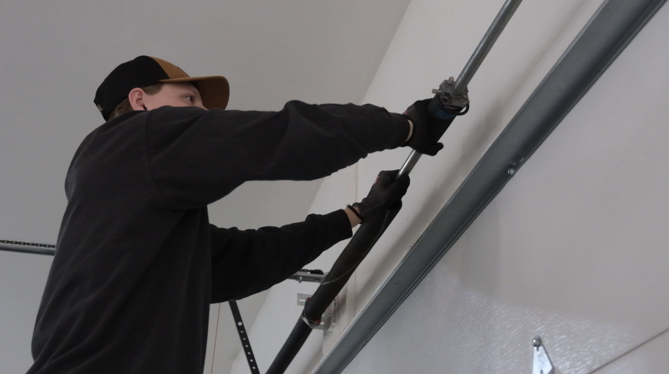 Technician working on the spring assembly above a garage door