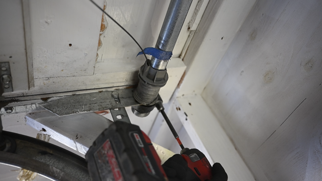 Garage door technician safely inspecting a torsion spring system
