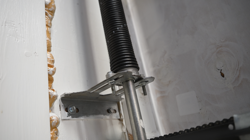 Close-up of a garage door torsion spring under tension