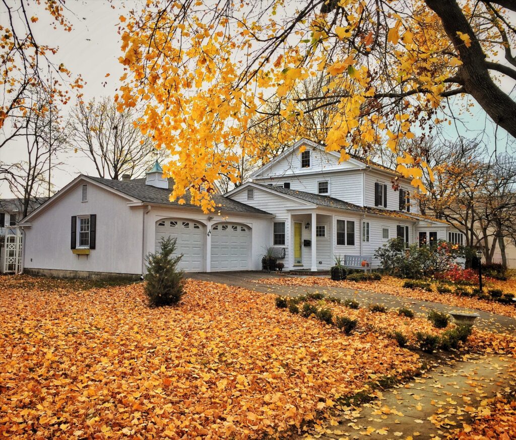 Residential garage door surrounded by fall leaves before winter