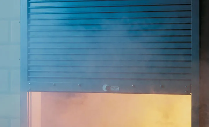 Steel rolling door partly lowered over an illuminated opening