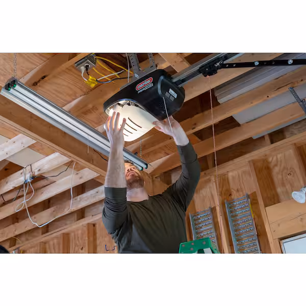 Person reaching toward the light housing on a ceiling-mounted garage door opener